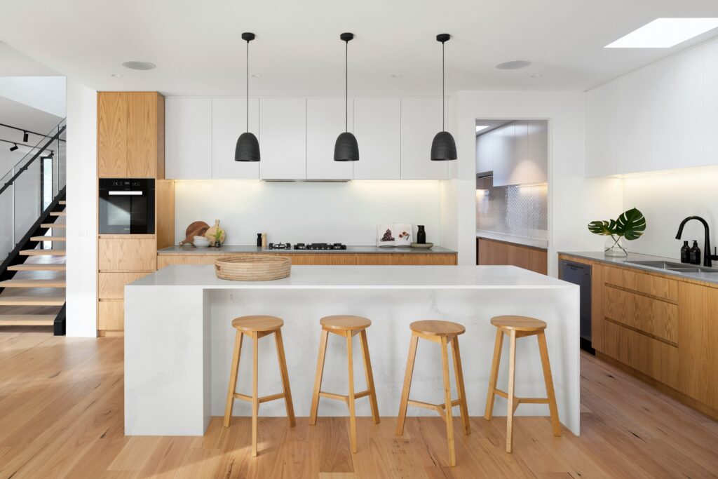 A modern kitchen with wooden stools.