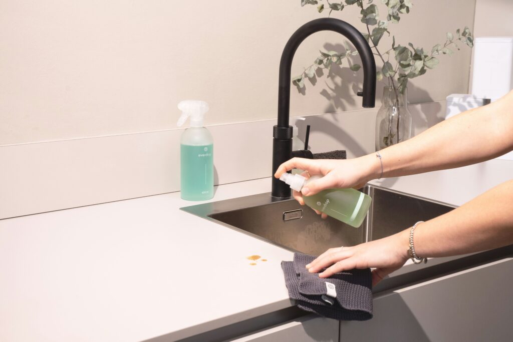 Hands scrubbing a kitchen counter top