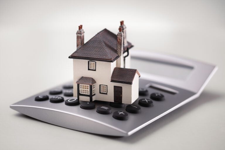 House resting on calculator concept for mortgage calculator